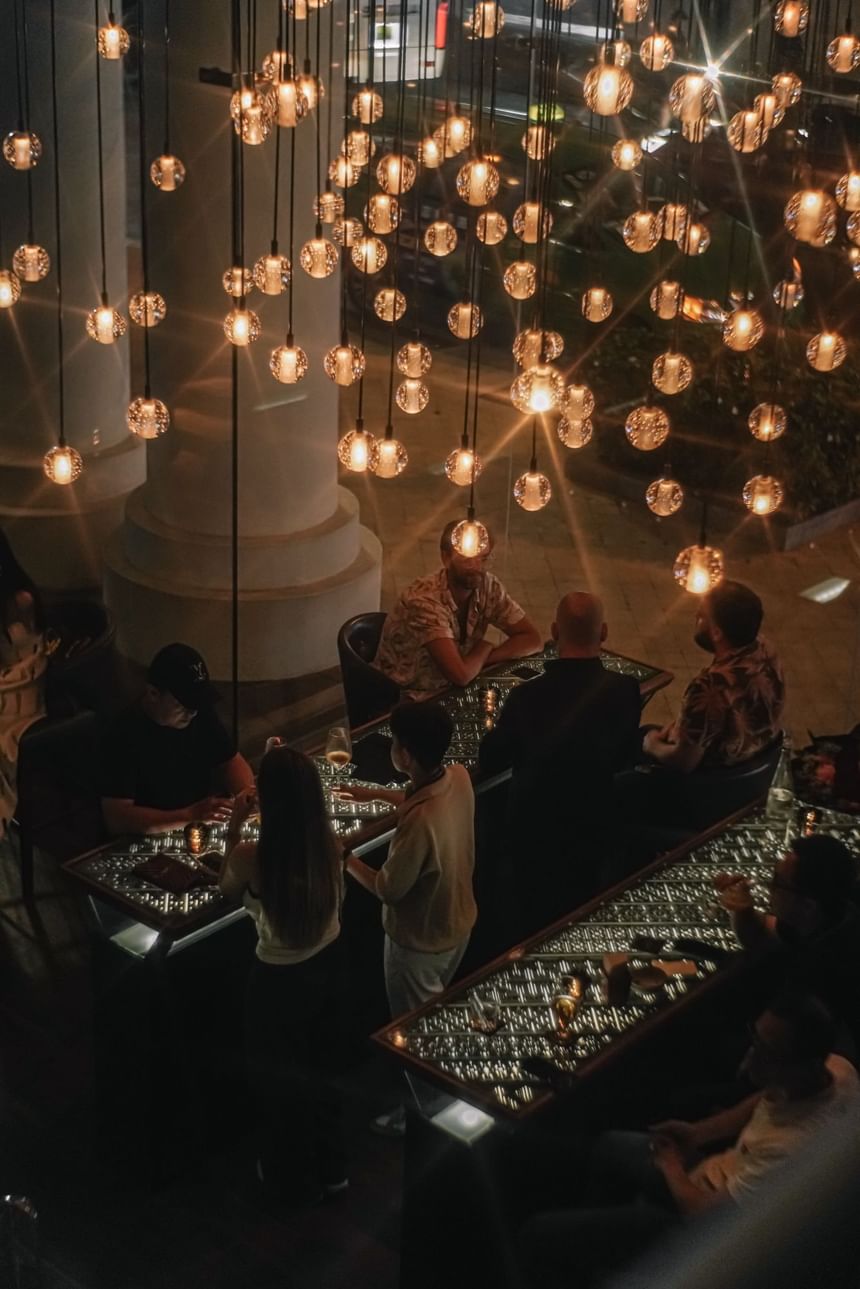 2 Lam Son aglow with decorative bulbs as guests enjoy drinks by the elegant tables at Park Hyatt Saigon