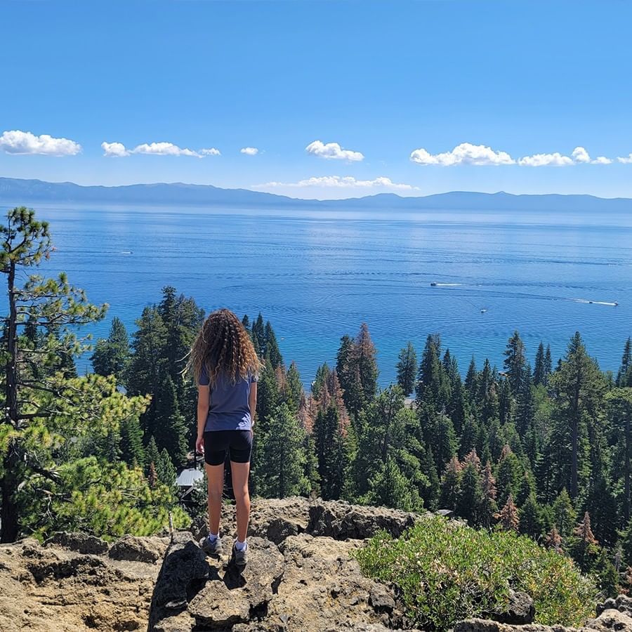 A woman hiking & looking at the lake near Granlibakken Tahoe