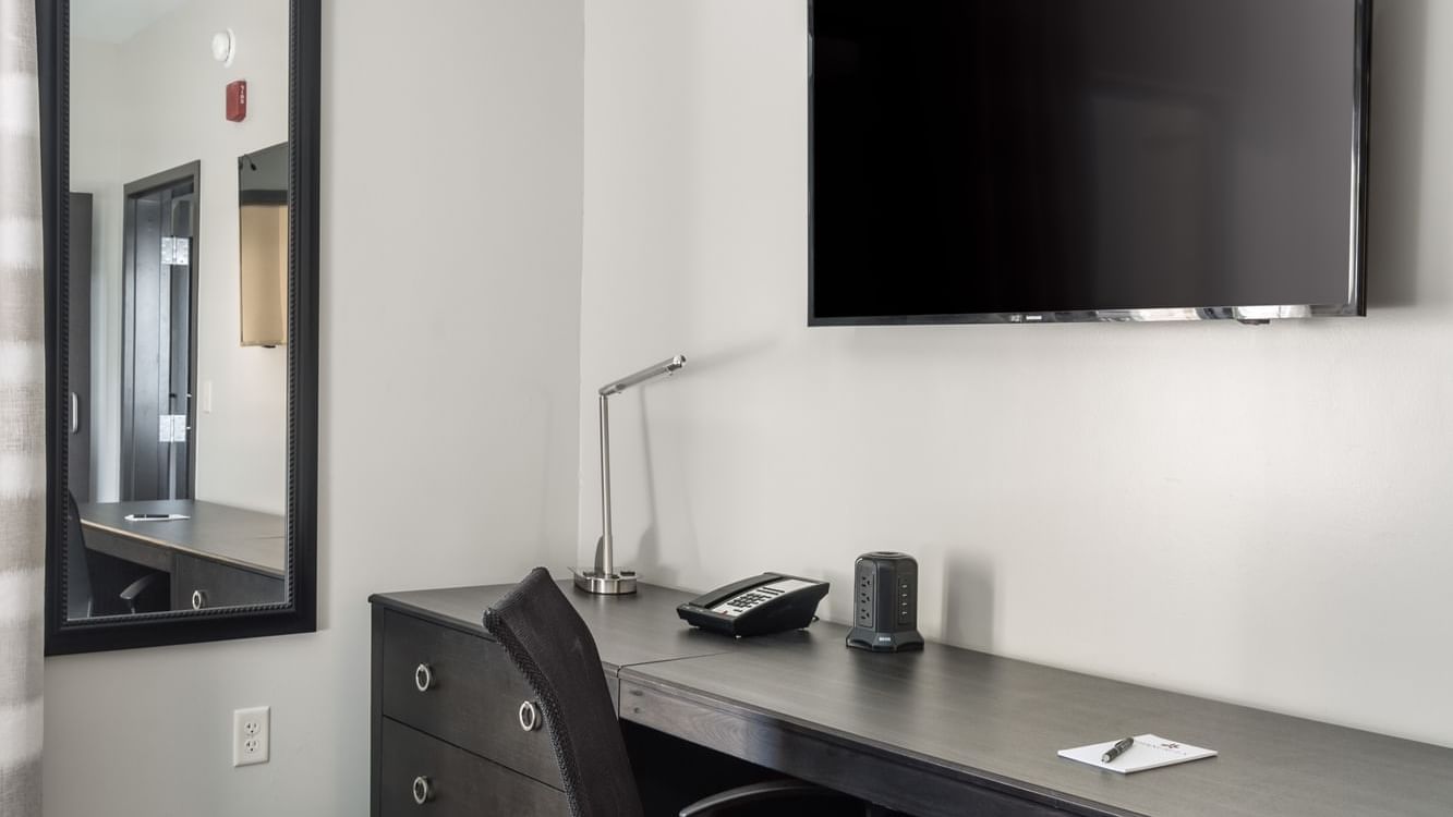Work desk and chair with a large screen TV and a mirror in Corner Suite at Shangri-La Monkey Island