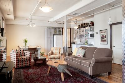 Living area with cozy sofa & kitchen pantry in Apartment 407 at Retro Suites Hotel