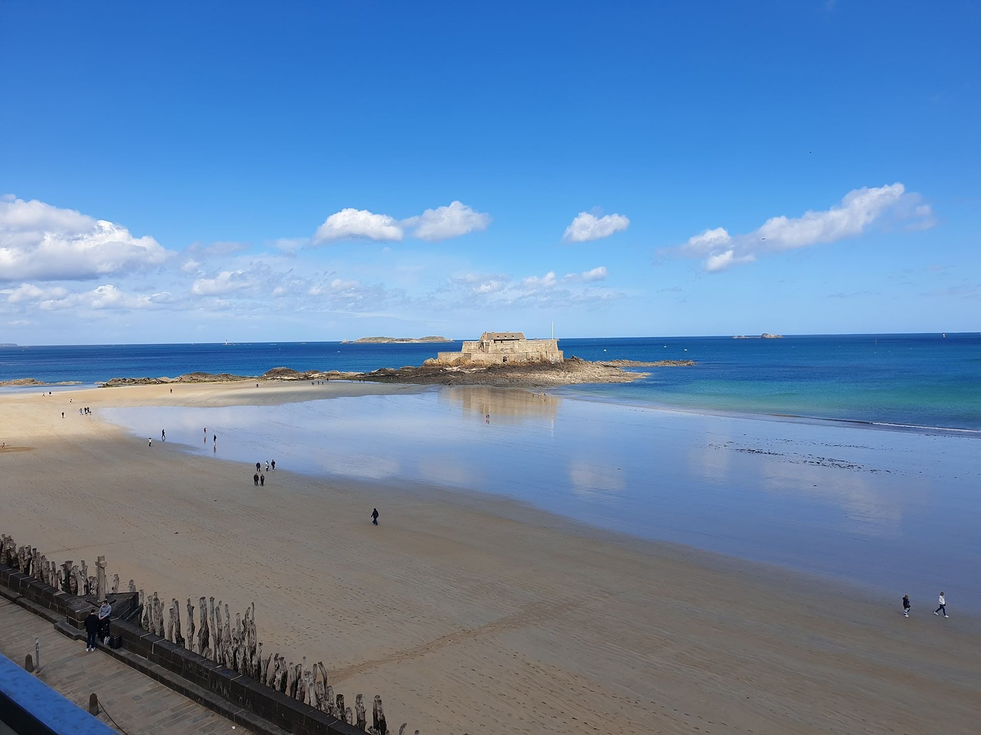 Plage de sable sereine avec un château au loin près de l'Oceania Saint-Malo