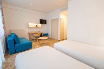 Standard Twin Room with TV, two beds, coffee table, work desk and couch at Metropol Hotel