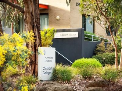 Sign for Chisholm College in front of the Union Building and Radford Hall at La Trobe University.