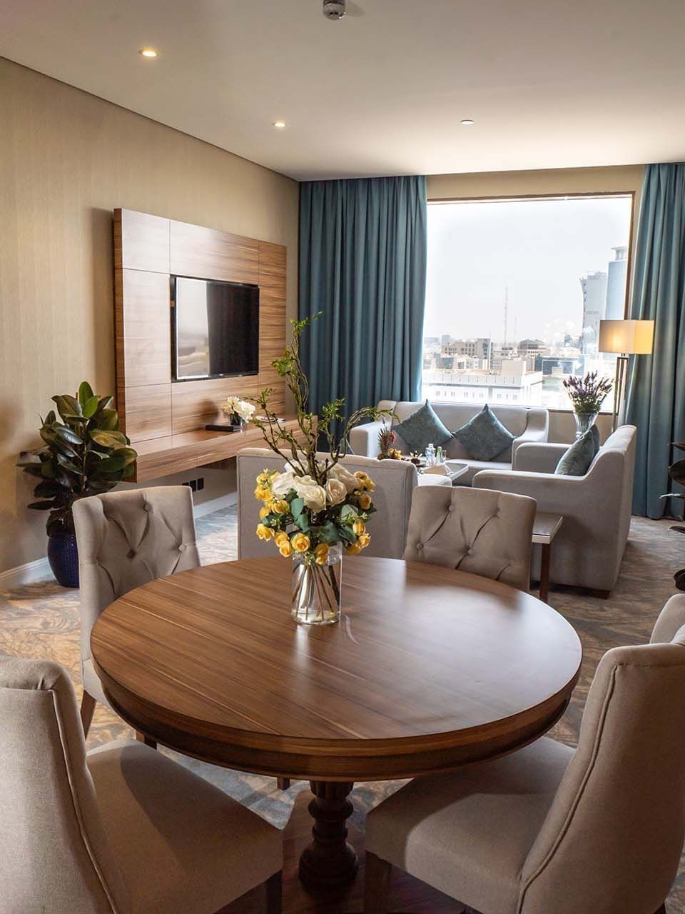 Executive Suite features Round wooden table with chairs in a living area at Cantonal Hotel by Warwick Riyadh