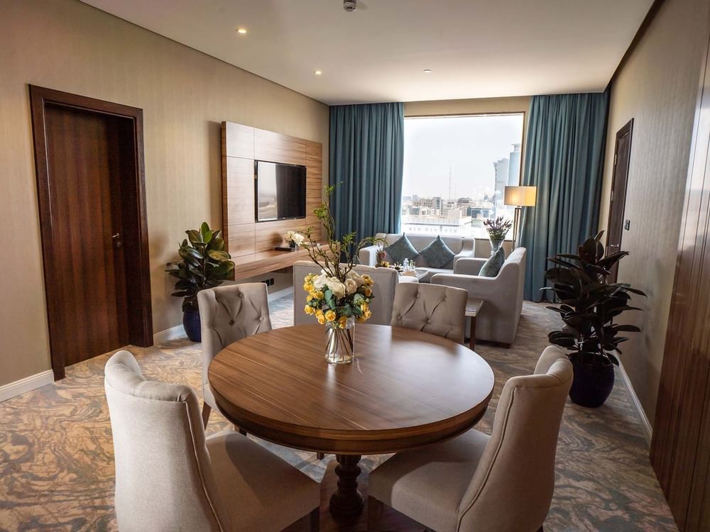 Executive Suite features Round wooden table with chairs in a living area at Cantonal Hotel by Warwick Riyadh