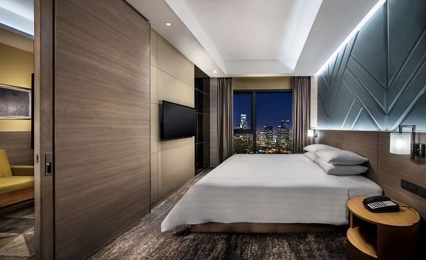 Family Suite Bedroom with a large bed, TV & cityscape view at Sunway Hotel Big Box