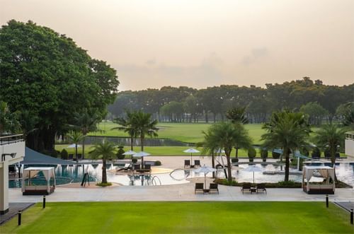 Outdoor pool with sun loungers & golf course view at Eastin Hotels