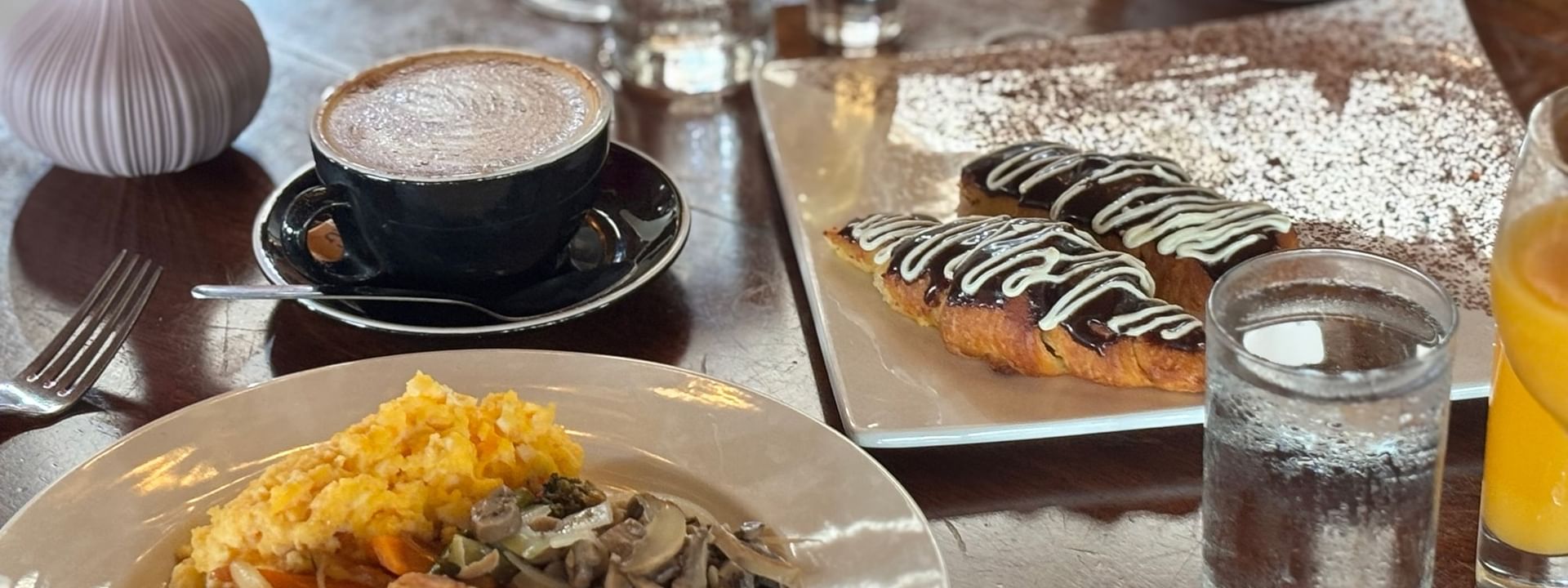 Breakfast dishes and drinks on a wooden table at Lagoon Terrace Restaurant in Efate at Warwick Le Lagon - Vanuatu