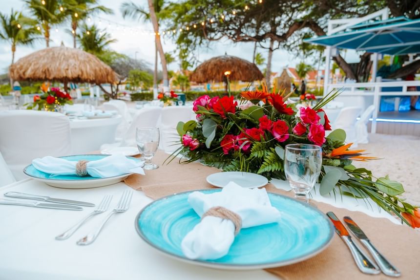 Close-up of beachside dining table arrangement with flower décor at Passions on the Beach