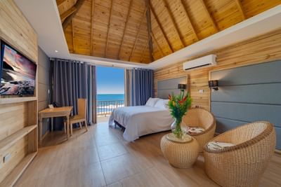 King bed and seating area with sea view in Junior Suite at Hotel Isla Del Encanto