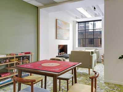 Bright communal lounge with children's play table, bookshelves, and seating area at UniLodge Auckland Central