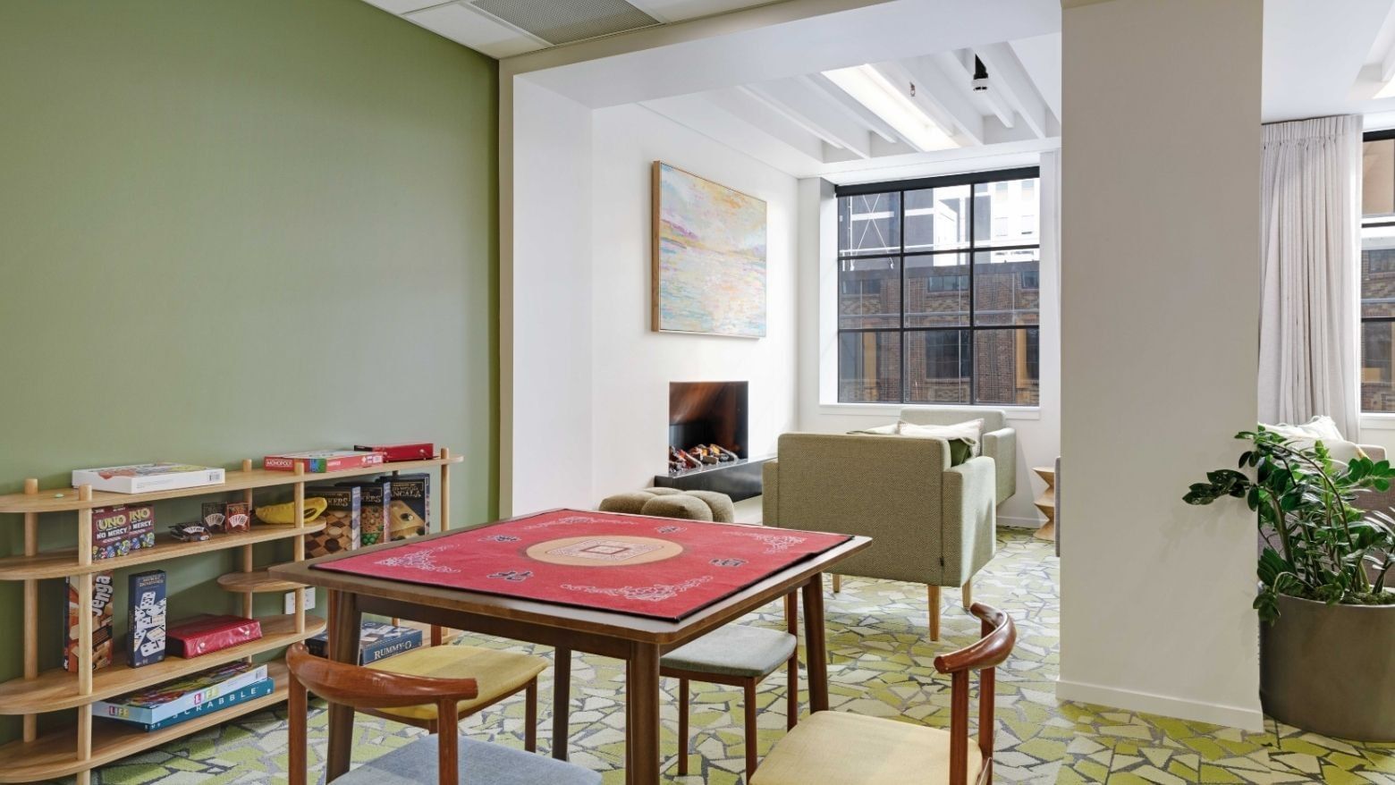Bright communal lounge with children's play table, bookshelves, and seating area at UniLodge Auckland Central