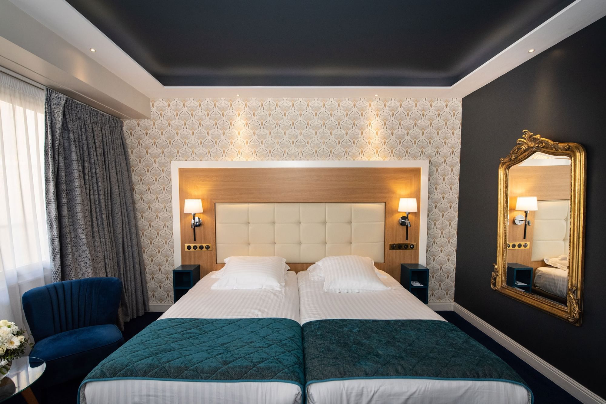 Modern luxurious bedroom featuring two twin beds, dark decor, and a vintage gold mirror at Splendid Hotel & Spa Nice