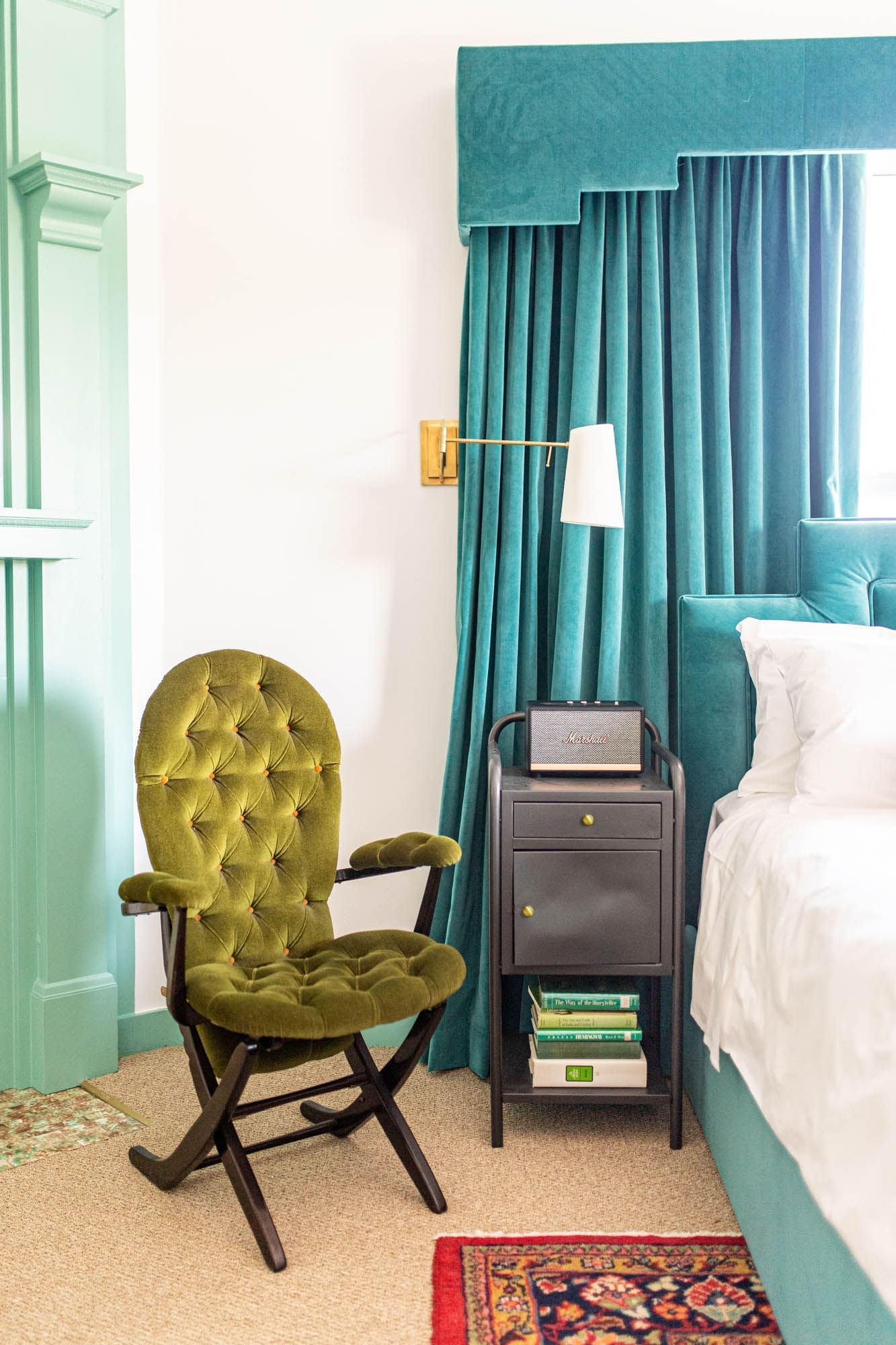 chair next to bed with blue bedframe