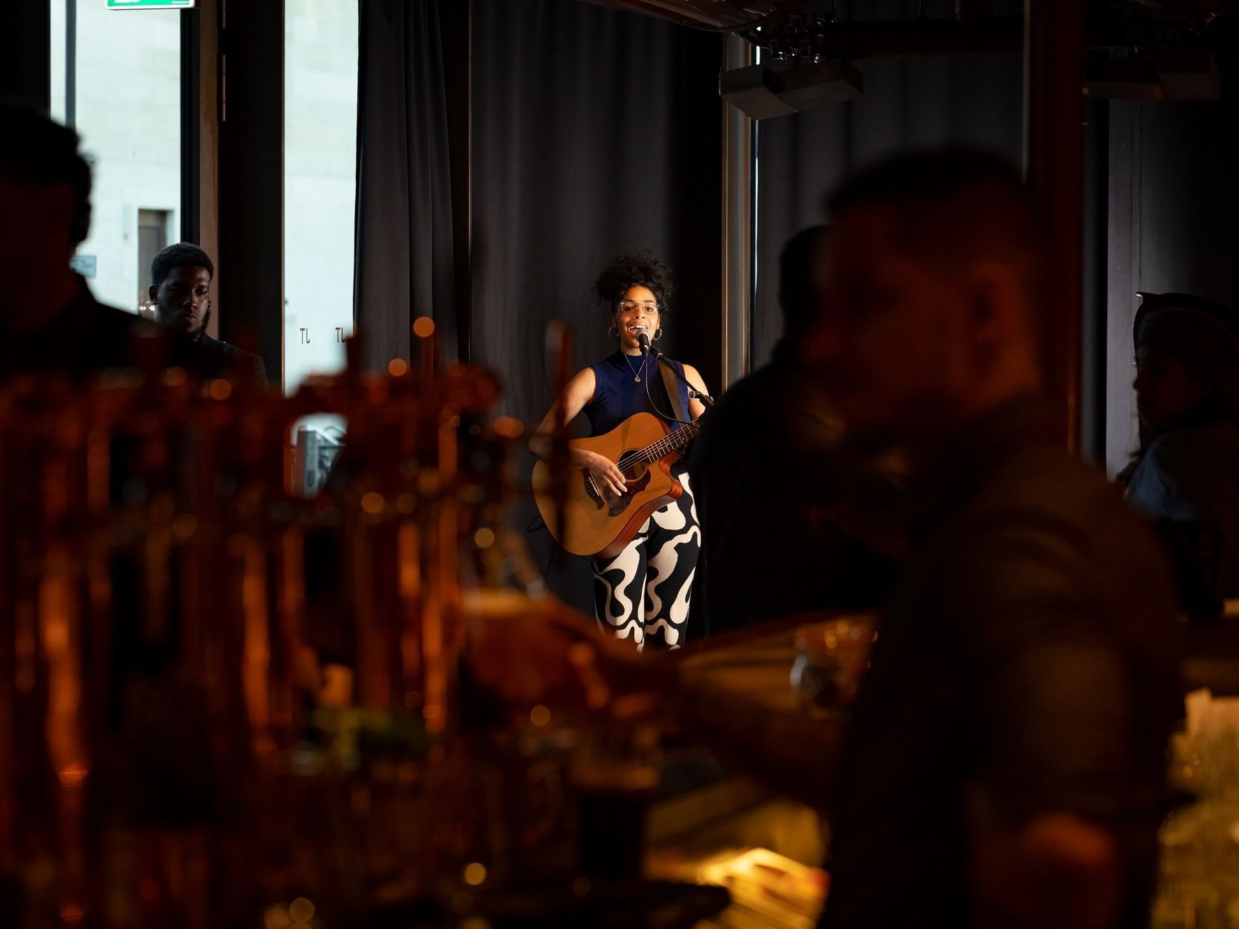 Women with a guitar performing live on a stage in an event at The Londoner Hotel