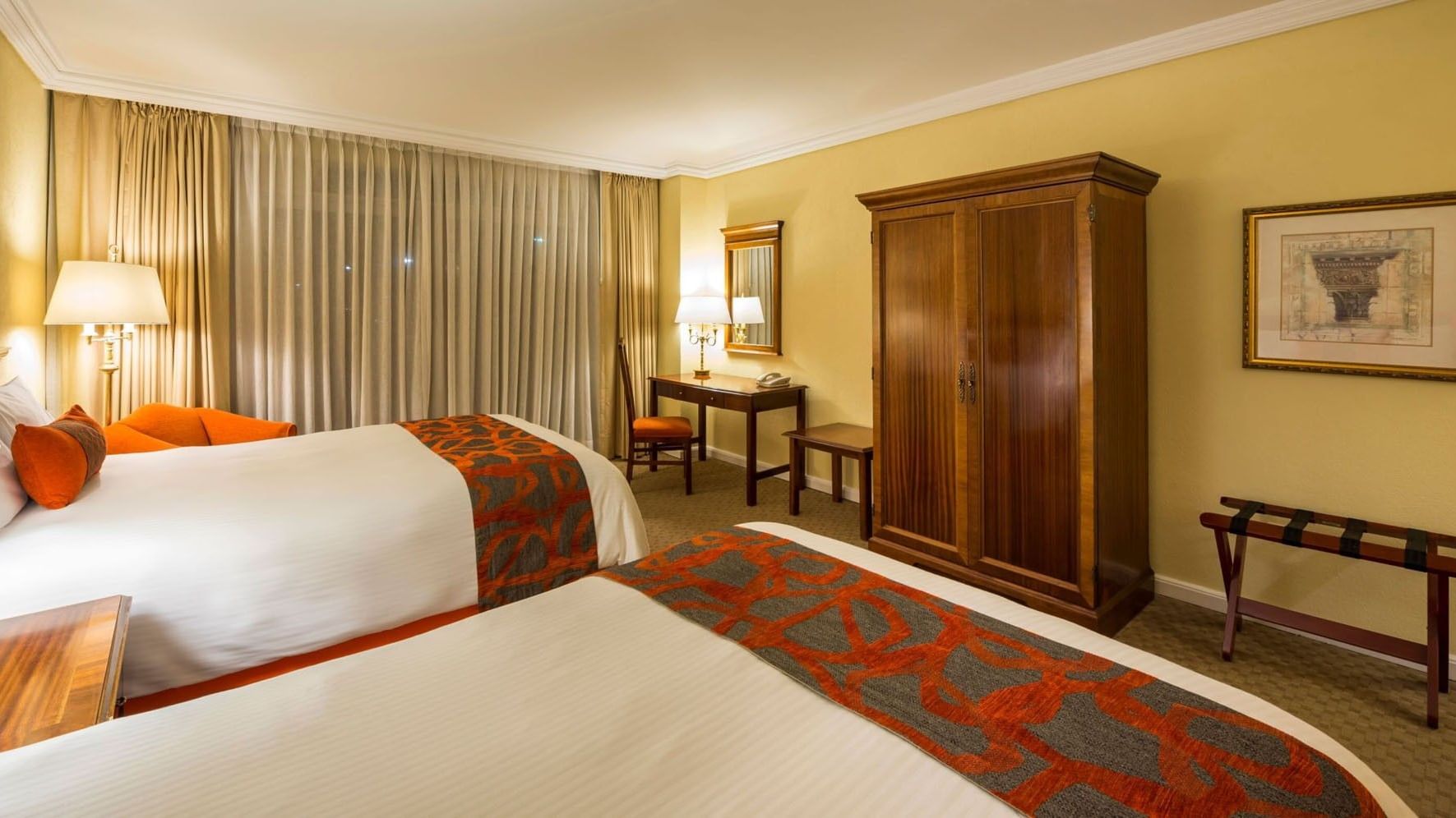 2 Double Deluxe room with a large wooden armoire and orange patterned bedding at Camino Real Puebla Angelopolis