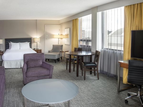 Coast Premium Queen Junior Suite with queen bed, seating area, dining table, and city views at Coast Prince George Hotel.