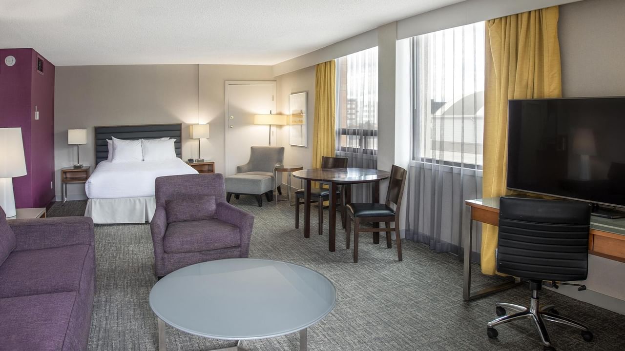Coast Premium Queen Junior Suite with queen bed, seating area, dining table, and city views at Coast Prince George Hotel.