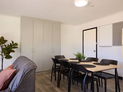 Living area with couch, dining table, and kitchen at UniLodge at Curtin University - Vickery House.