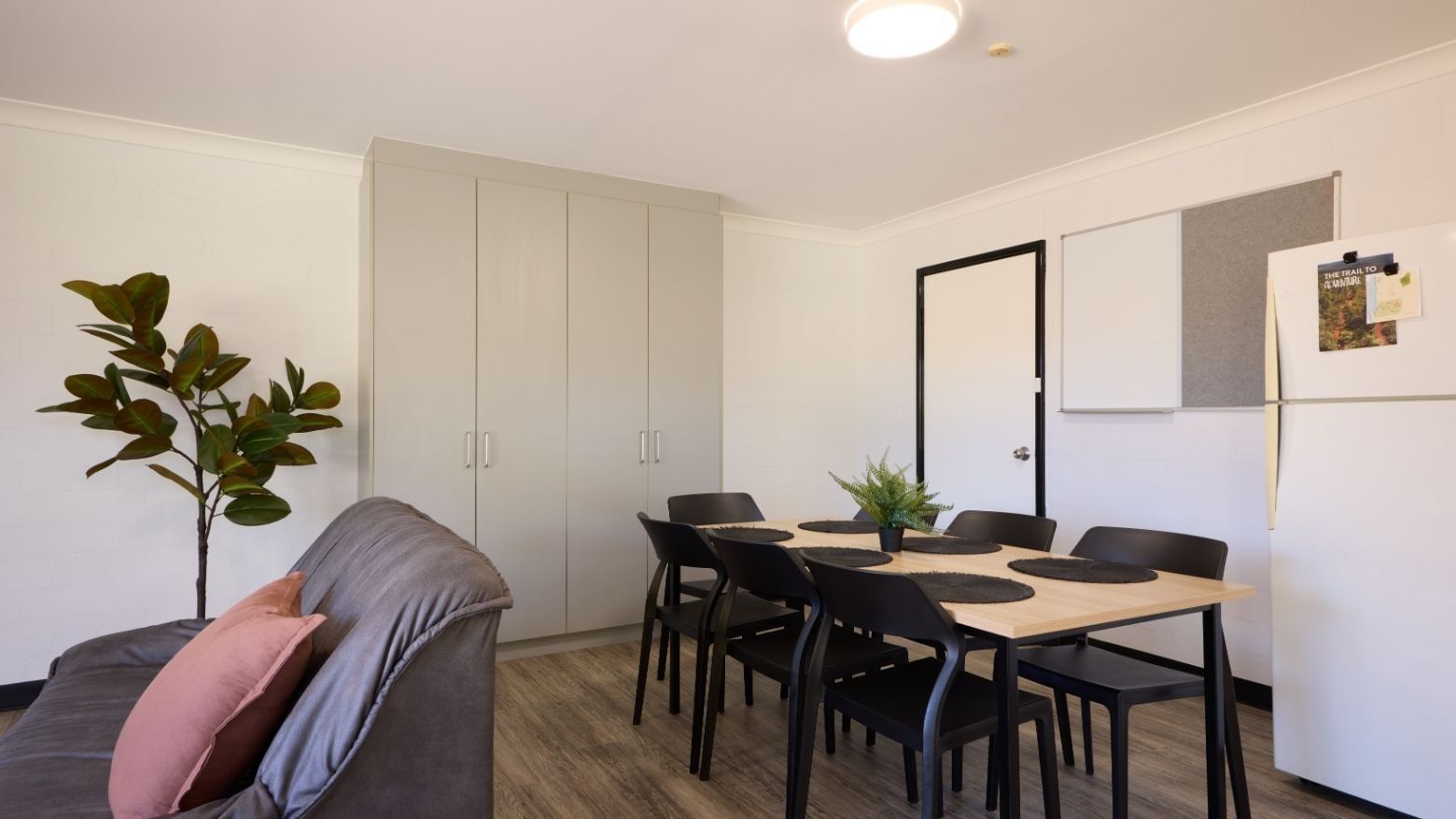 Living area with couch, dining table, and kitchen at UniLodge at Curtin University - Vickery House.