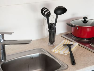 Typical kitchen featuring sink, stove, fridge & microwave