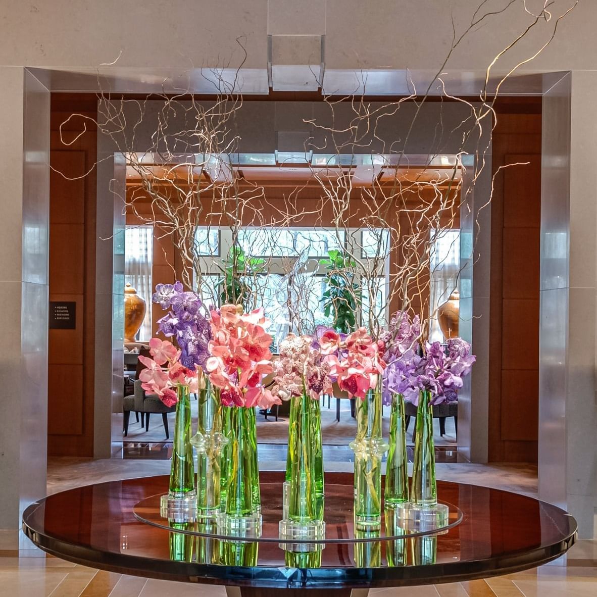 Vases filled with colorful flowers on a wooden table at Umstead Hotel and Spa