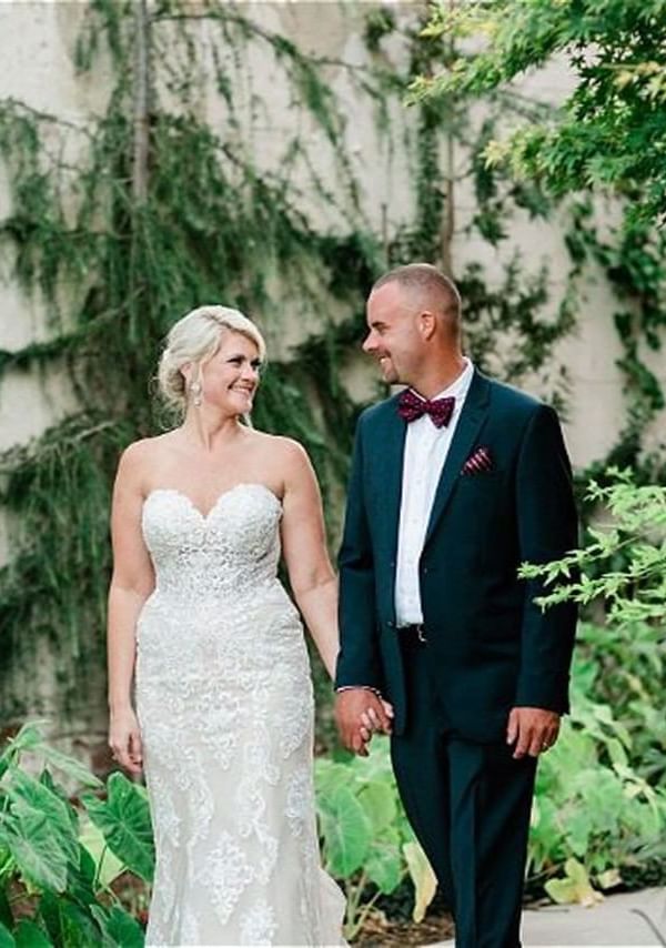 Wedded couple walking down a green lawn in Inn at the Crossroads