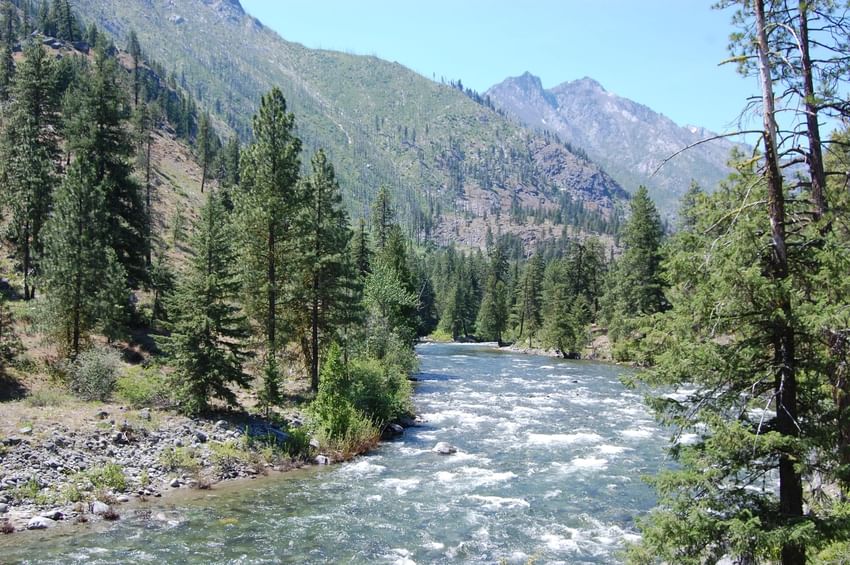 Mountain river with forest near the Sleeping Lady at sunset