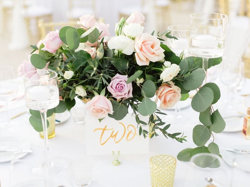 Elegant wedding centerpiece with pink and white roses, eucalyptus leaves, and floating candles at The Explorean Resorts