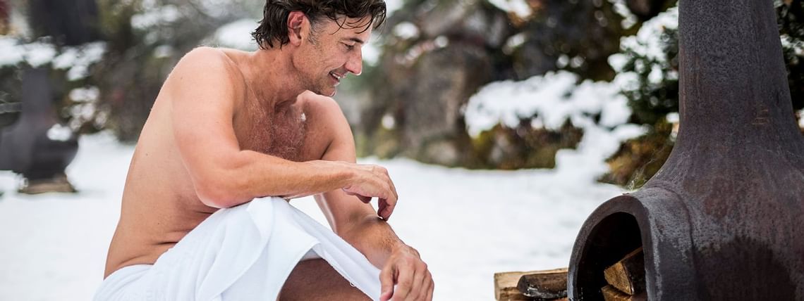 Gast vor Heizofen im Winter im Aussenbereich im Wellnesshotel Liebes Rot Flüh, Tannheimer Tal