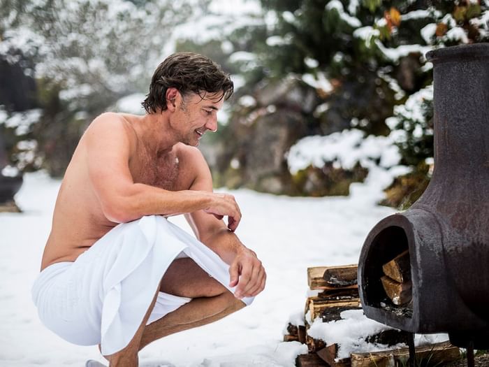 Gast vor Heizofen im Winter im Aussenbereich im Wellnesshotel Liebes Rot Flüh, Tannheimer Tal