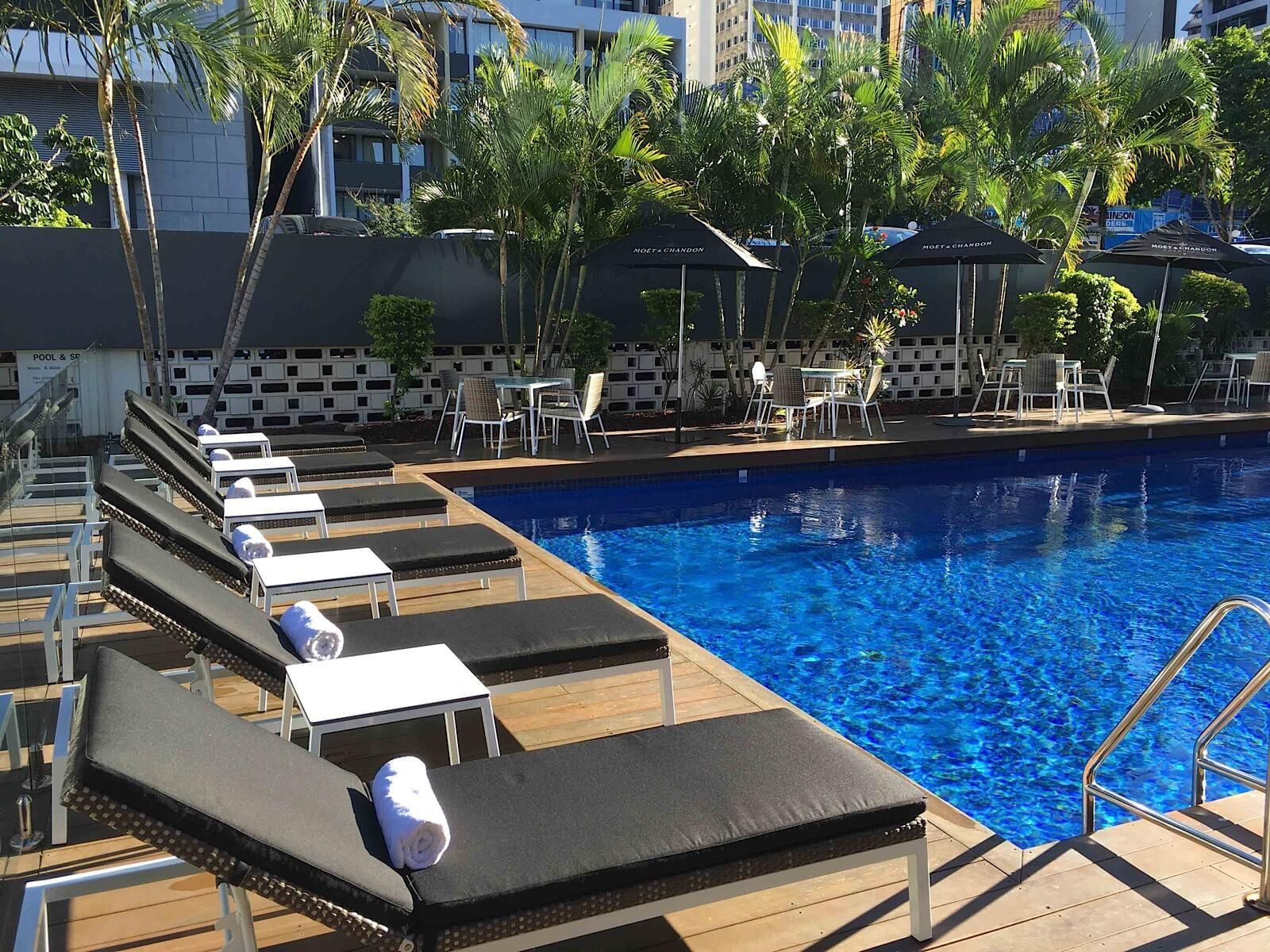 Loungers in the pool area at Royal on the Park Hotel