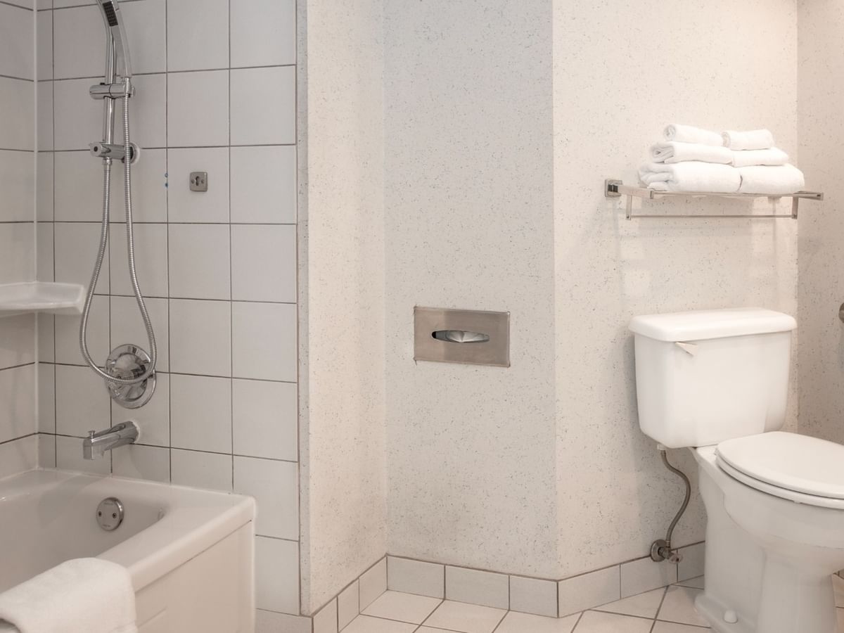 Coast Accessible King bathroom with bathtub, showerhead, toilet at Coast Lonsdale Quay Hotel