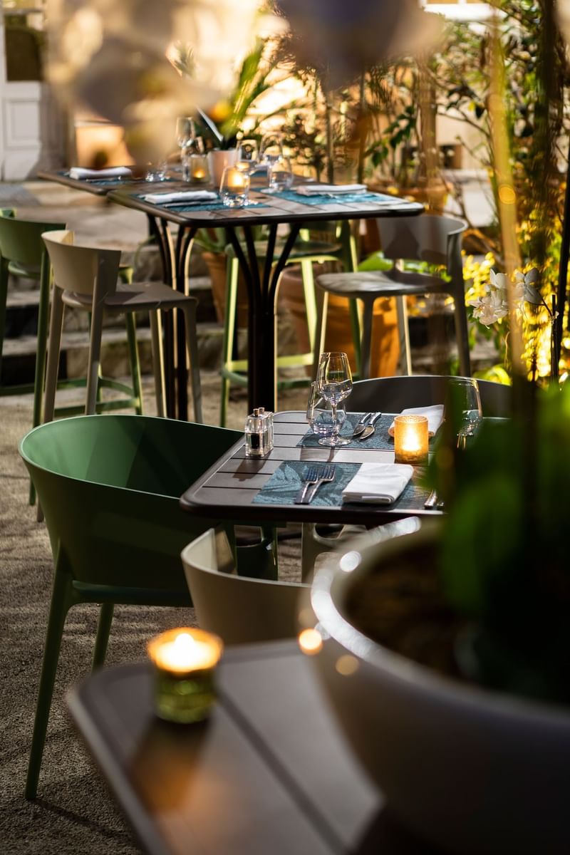 Outdoor dining tables arranged at night at Oceania Hotels