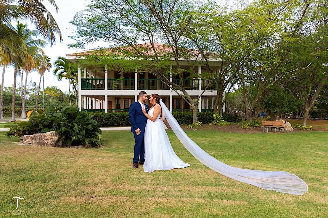 A wedding couple standing near the hotel at Copamarina Weddings