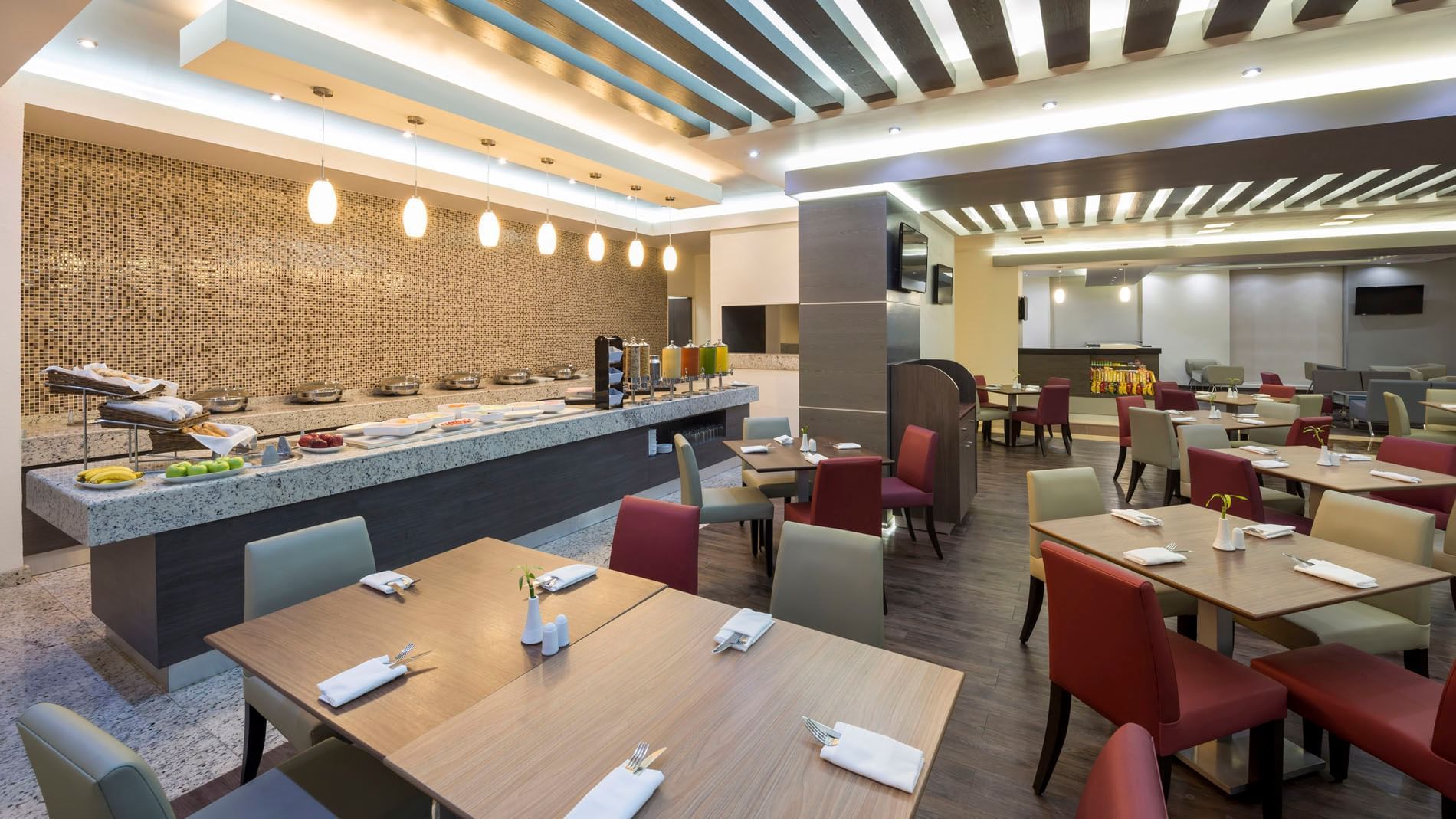 Stock Cafe interior with warm lighting and plush seating, featuring a buffet area at Real Inn San Luis Potosi