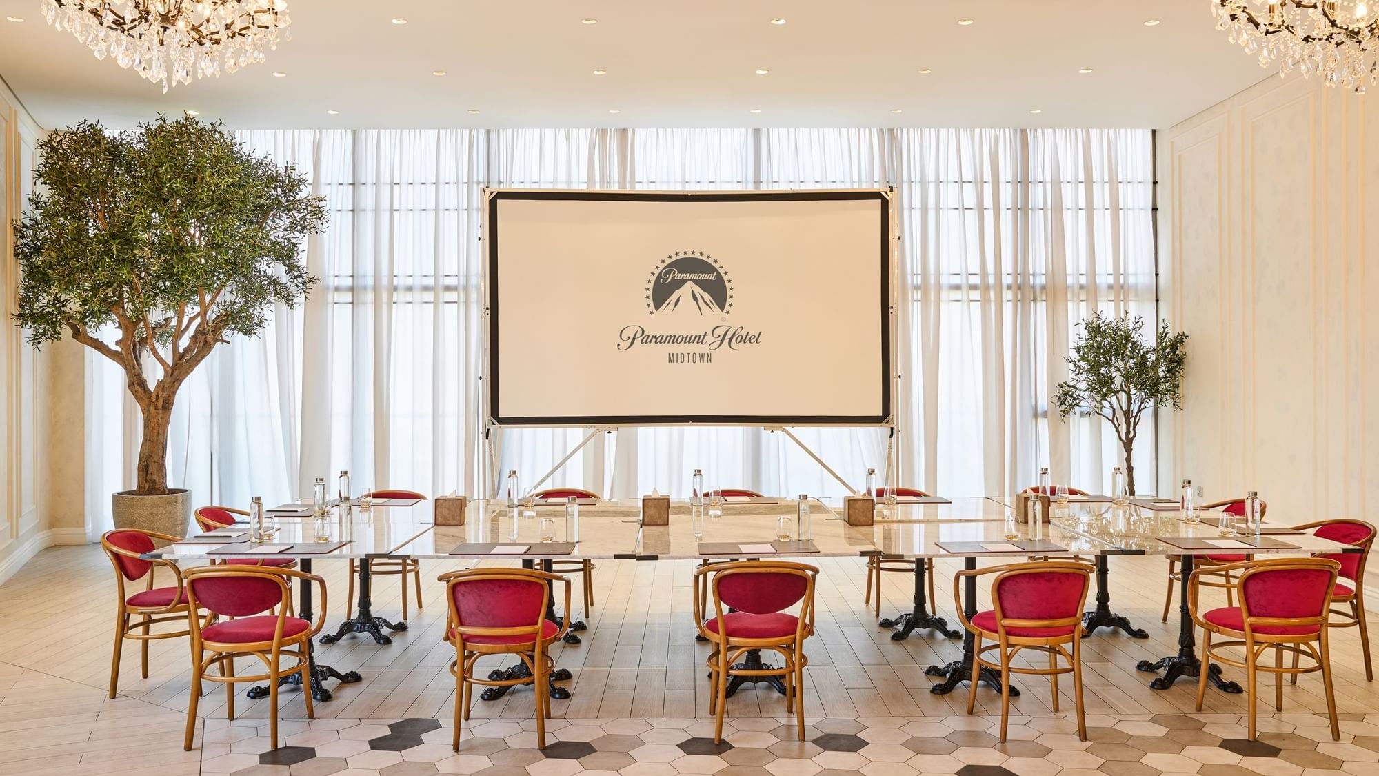 Meeting space at Paparazzi restaurant venue, Paramount Hotel Midtown, with tables arranged in rows facing a projector screen