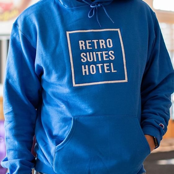 A man wearing a blue hoodie with hotel name at Retro Suites Hotel