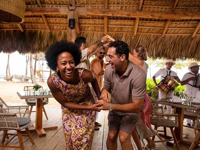 Couple of people are dancing with each other by the beachside at Live Aqua Resort Punta Cana