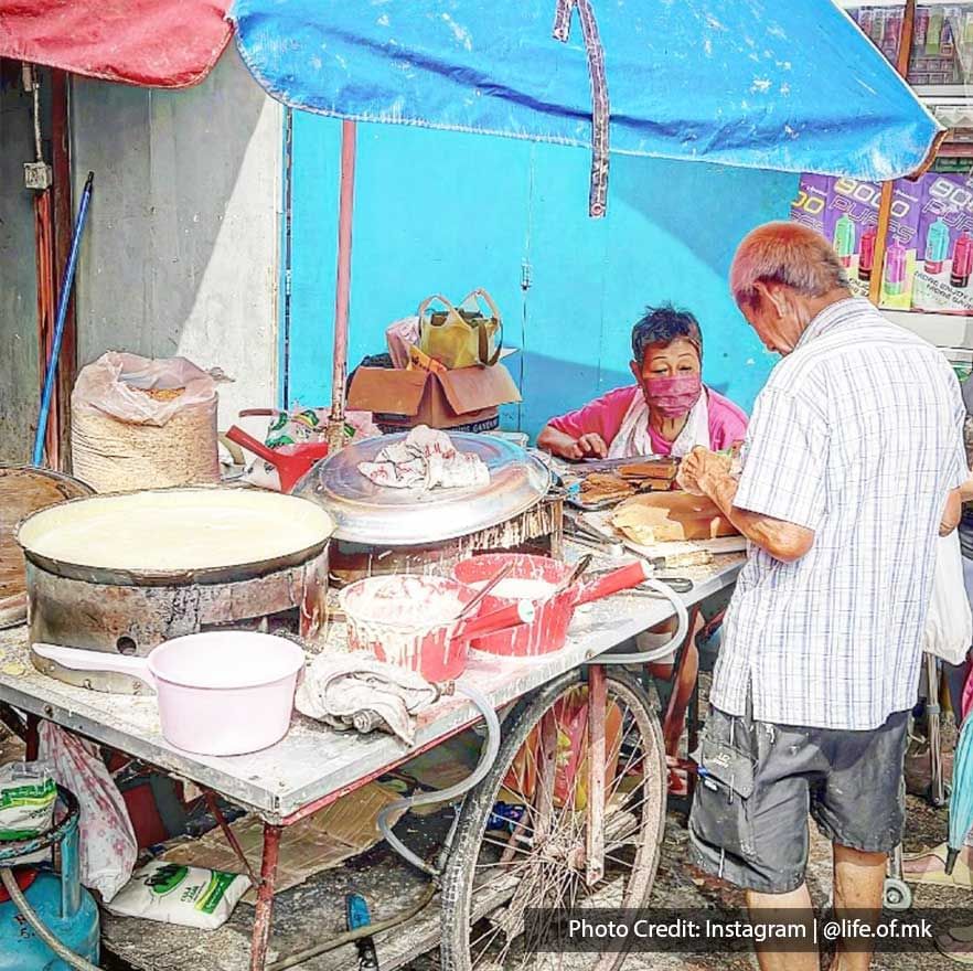 Elderly couple behind an Ancient Treak Cart with good near Imperial Lexis Kuala Lumpur