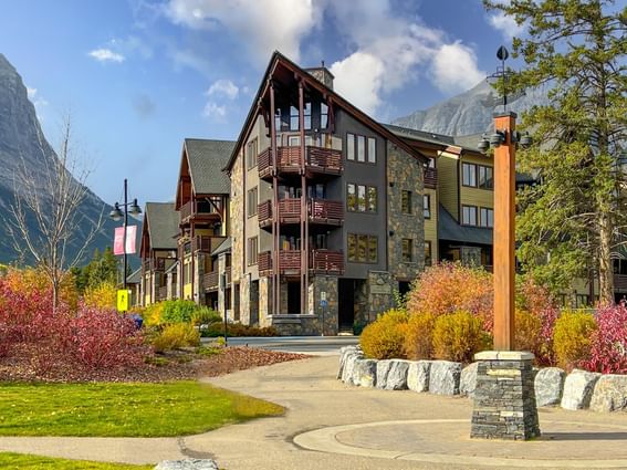 Rundle Cliffs Lodge with stone and wood façade by foliage at Spring Creek Vacations Canmore Condos