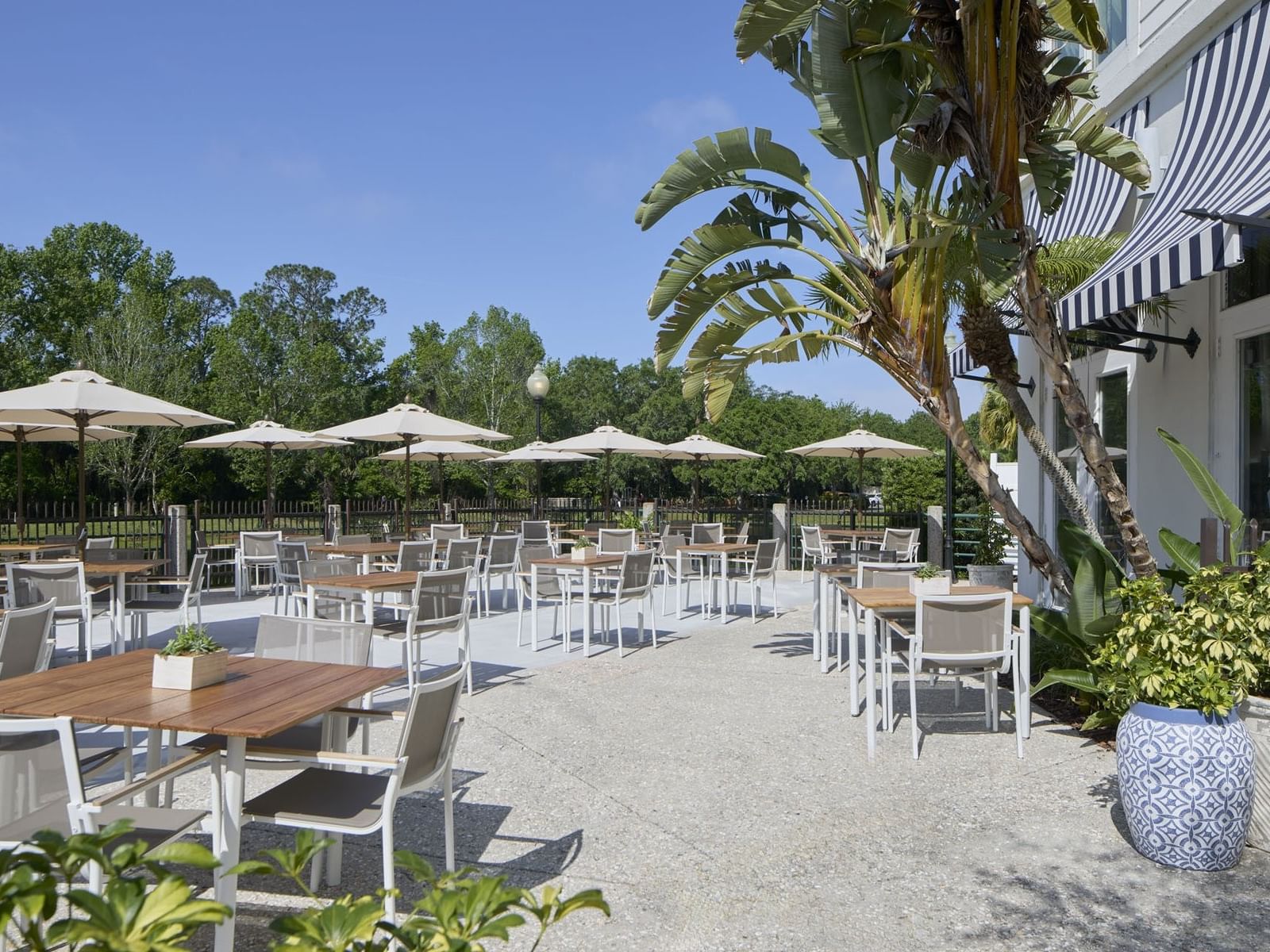 Lakeside Terrace of The Inn at Celebration, with tables under umbrellas, surrounded by palm trees