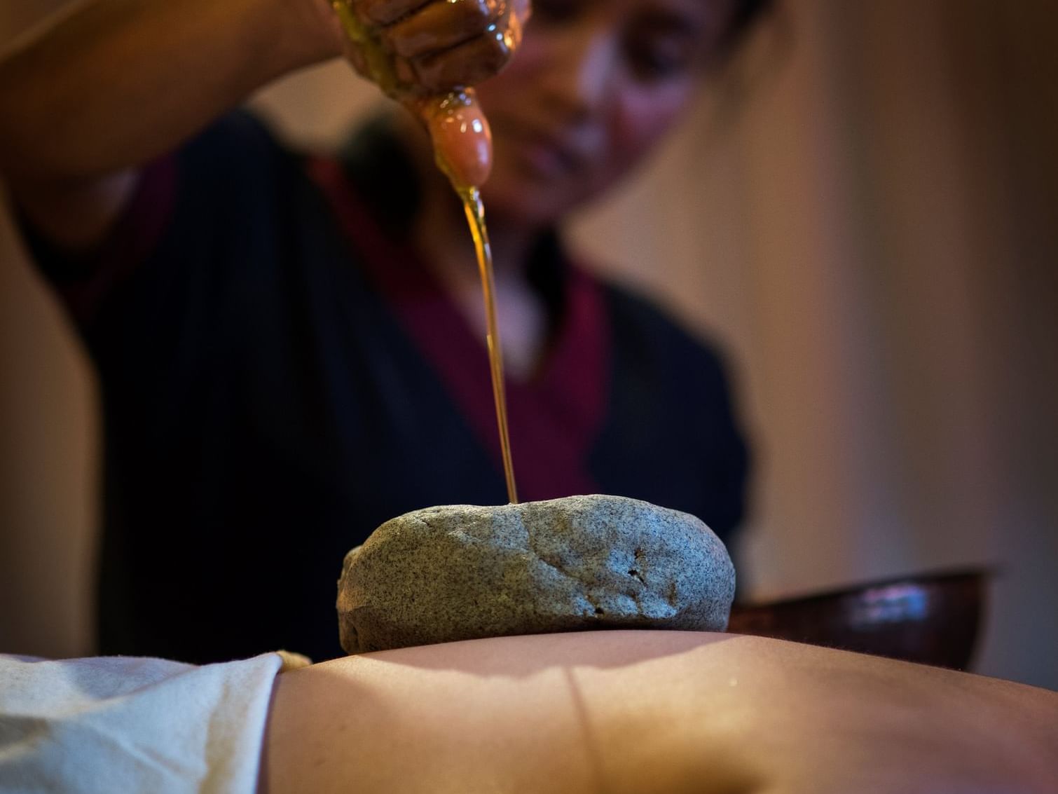 Lady poring oil for a treatment in Pancha Kosha Body Care at Dwarika's Hotel Kathmandu