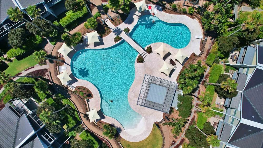 Aerial shot of lagoon pool with beautiful gardens surrounding