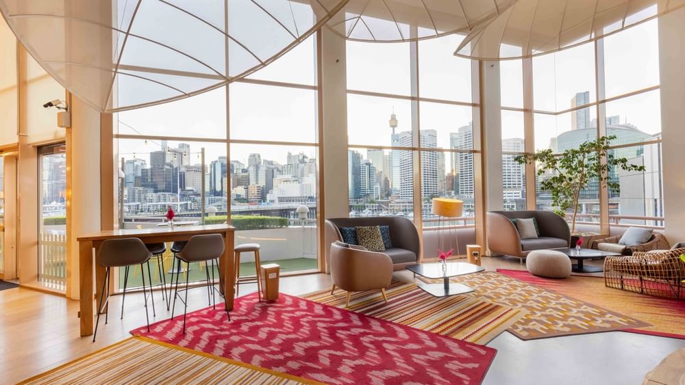 Spacious lounge area with panoramic city and harbour views in The Chemney Lounge at Novotel Sydney on Darling Harbour