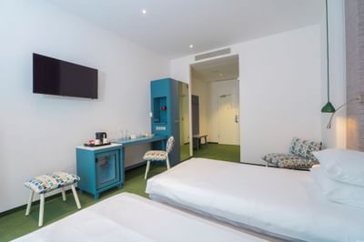 Executive Room with twin beds, cabinet, TV and comfy chair at Metropol Hotel