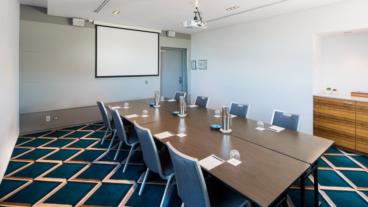 Meeting table arranged with the screen for formal meetings at Pullman Magenta Shores