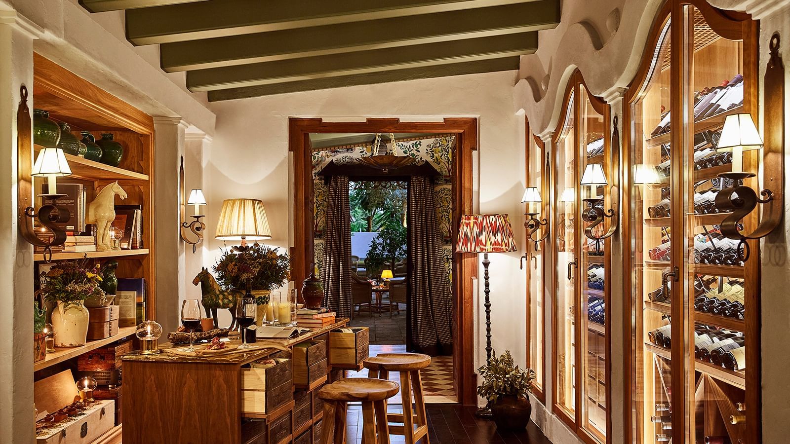 Cozy wine library with backlit bottles in wall cabinets and a wooden counter at Marbella Club