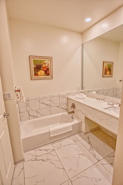 Marbled bathroom vanity & bathtub area at Trianon Bonita Bay