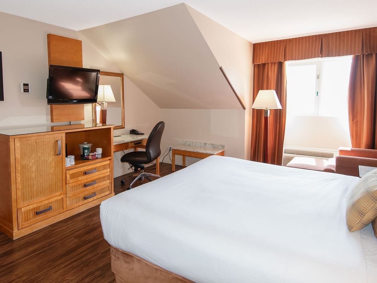 Hotel room with king bed, TV, work desk and window